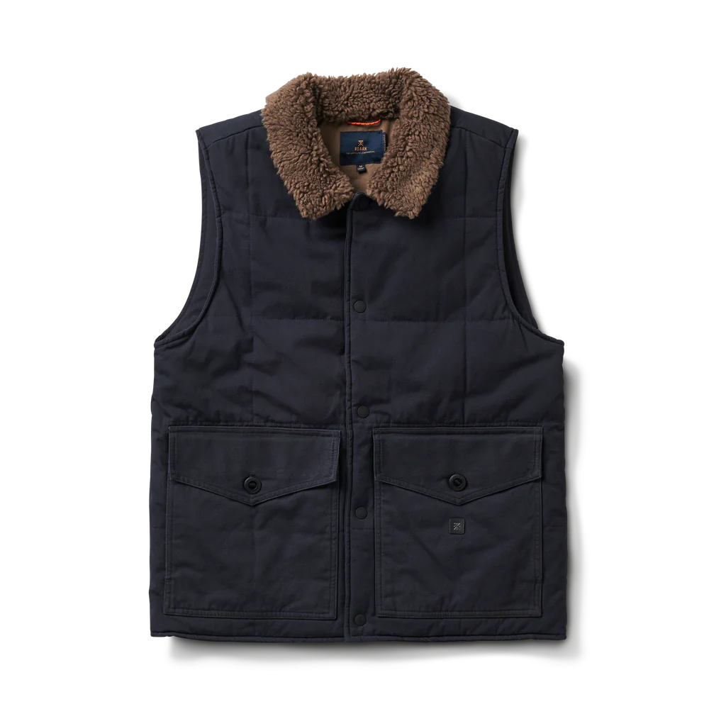 Chaqueta manga corta color azul oscuro con cuello de polar color café. Tiene 2 bolsillos delanteros con botón de cierre.