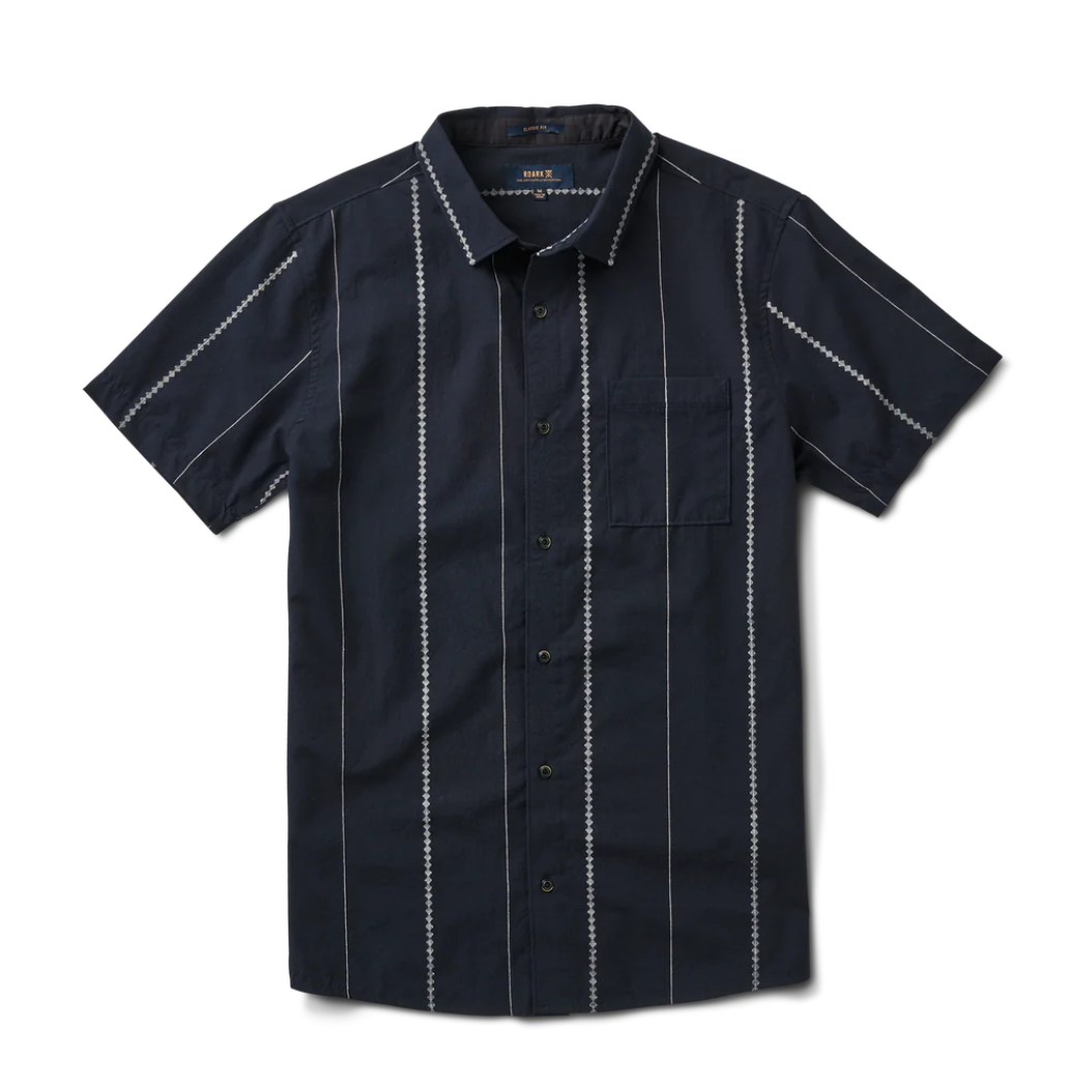 Camisa manga corta color azul oscuro con lineas blancas, de diferentes grosores y diseños, espaciadas entre sí.